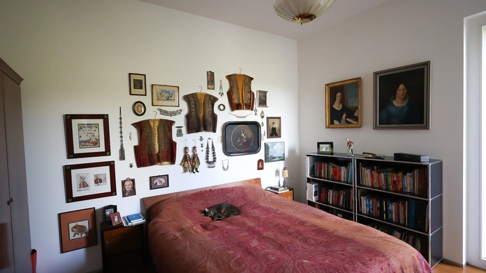 Im Haus der Familie Benndorf-Lang wird ein Rundgang zu einer kleinen Weltreise. Ein josefinischer Spiegel aus Kroatien, ein tibetanischer Tragaltar oder türkische Männerjäckchen, die die Wände des Schlafzimmers zieren, in dem Katze Carla (im Bild) bevorzugt schlummert. Dieses Haus im Grazer Bezirk Mariatrost ist ein echtes Schmuckkästchen.