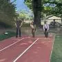 Drei Menschen stehen am Start einer Laufbahn