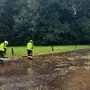 Feuerwehrleute machen eine verlegte Straße frei