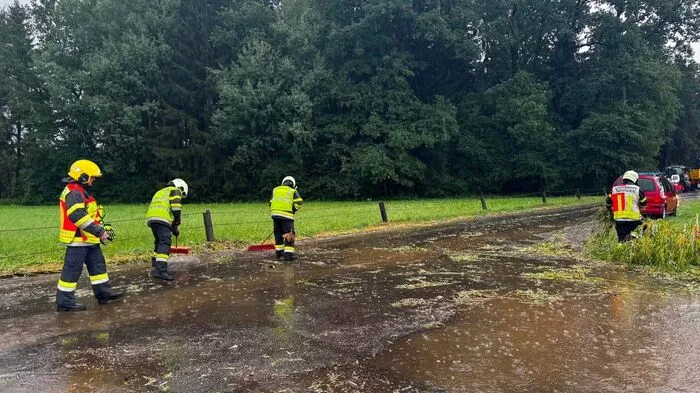 Feuerwehrleute machen eine verlegte Straße frei