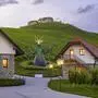 Ein Weingut bei Dämmerung. Im Vordergrund sind zwei Häuser zu sehen. Im Hintergrund thront die Burg Taggenbrunn über dem Gut.