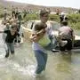 epa00795279 A Lebanese boy carries a girl as refugees trying to return home ford the Litani River to reach their homes near the south Lebanon city of Marjayoun Tuesday 15 August 2006. Tens of thousands of Lebanese who fled the 34-day long conflict between Hezbollah and the Israeli Army struggled with congested and destroyed roads to reach their homes. EPA/ALI HAIDER;nahost konflikt, israel, libanon, libanon krieg