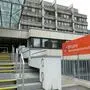 Ein großes graues Gebäude mit Stiegen und Fenstern