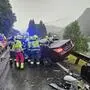 Man sieht ein Unfallwrack und viele Einsatzkräfte rundherum