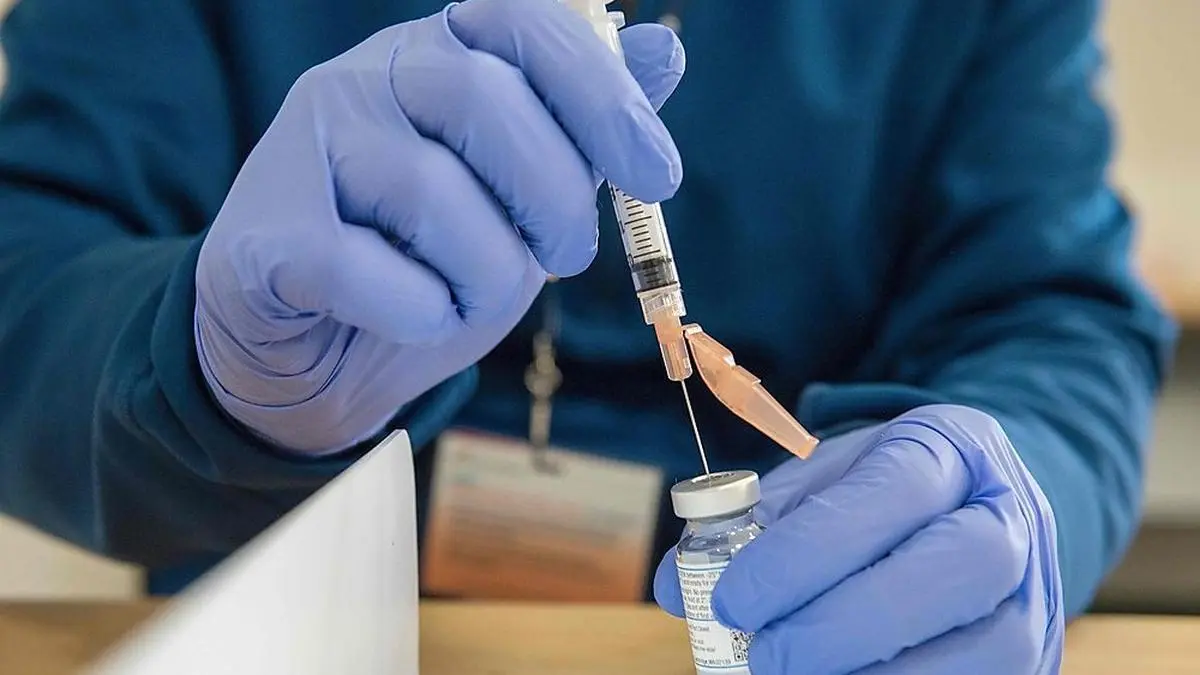 Pharmacist Jason Hyde fills syringes with the Moderna Covid-19 vaccine as first responders wait to receive it at UMass Memorial Hospital in Marlborough, Massachusetts on January 12, 2021. - First Responders started to receive their vaccinations on January 11, as part of the phase one of vaccinations roll out in Massachusetts. (Photo by Joseph Prezioso / AFP)