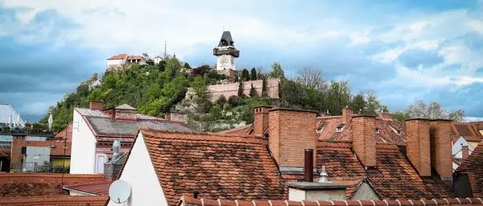 Sujetfoto: Die Dachlandschaft der Grazer Altstadt mit dem Uhrturm und Schloßberg im Hintergrund