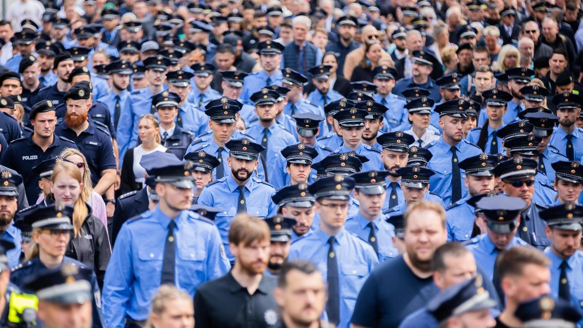 Polizisten nehmen an einem Schweigemarsch der „Blaulichtfamilie“ von der Deutschen Polizeigewerkschaft (DPolG) und der Gewerkschaft der Polizei (GdP) in Gedenken an den durch einen Messerangriff in Mannheim zu Tode gekommenen Polizisten teil.