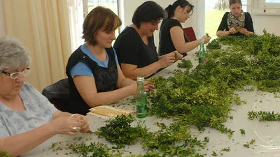 Beim Binden der Buchsbaum-Reifkränze für den Tanz helfen alle zusammen