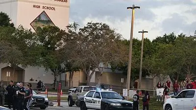 Marjory Stoneman Douglas High School staff, teachers and students return to school greeted by police and well wishers in Parkland, Florida on February 28, 2018. A former student, Nikolas Cruz, opened fire at Marjory Stoneman Douglas High School leaving 17 people dead and 15 injured on February 14..Students grieving for slain classmates prepared for an emotional return Wednesday to their Florida high school, where a mass shooting shocked the nation and led teen survivors to spur a growing movement to tighten America's gun laws. The community of Parkland, Florida, where residents were plunged into tragedy two weeks ago, steeled itself for the resumption of classes at Marjory Stoneman Douglas High School, where nearby flower-draped memorials and 17 white crosses pay tribute to the 14 students and three staff members who were murdered by a former student.. / AFP PHOTO / RHONA WISE