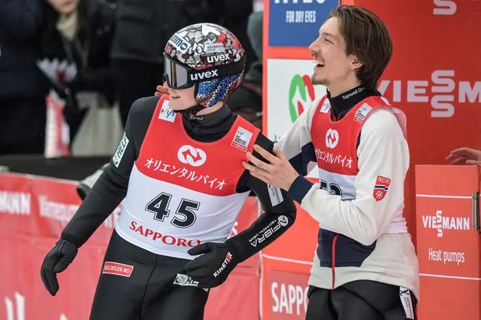 Norway's Johann Andre Forfang (R) congratulates Norway's Marius Lindvik (L) after his second jump to take overall second place on the second day of the men's FIS Ski Jumping World Cup competition in Sapporo on February 16, 2025. (Photo by Richard A. Brooks / AFP)
