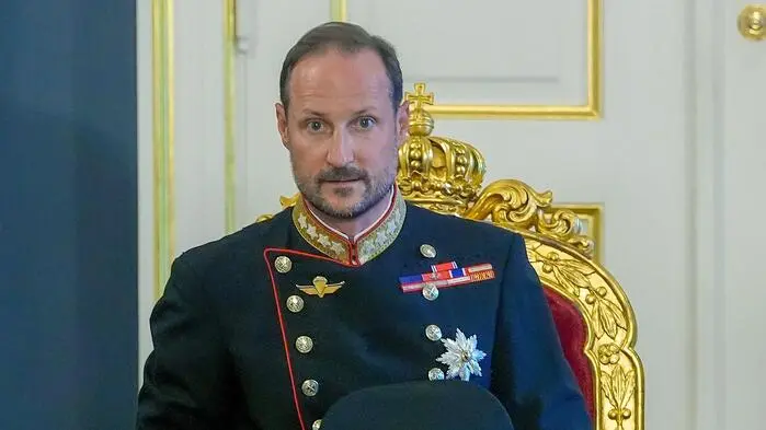Ein Mann in Uniform sitzt auf einem goldverzierten Stuhl