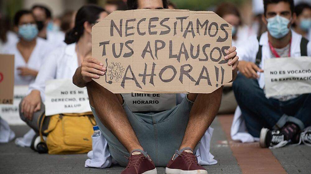 Madrids Ärzte sind verzweifelt: &quot;Wir brauchen euren Applaus jetzt&quot;, steht auf dem Schild eines Mediziners