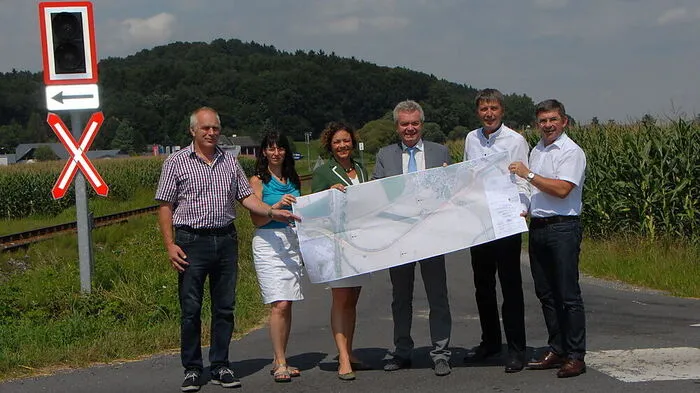 Landesrat Lang mit den Abgeordneten Schweiner und Fartek, Bürgermeister Winkelmaier, Vize Rath und Planerin Hofer an der Eisenbahnkreuzung in Brunn, an der das neue Straßenstück der L 222 beginnen wird, das das Land finanziert