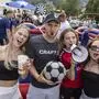 Zwei Männer und vier Frauen lachen in die Kamera. Ein Mann hält einen Fußball in der Hand, eine Frau ein Megafon.
