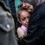 TOPSHOT - A Palestinian woman holds a child as they mourn their relatives killed in Israeli bombardment in front of the morgue of the Al-Shifa hospital in Gaza City on March 15, 2024, amid the ongoing conflict between Israel and the Palestinian Hamas movement. (Photo by AFP)