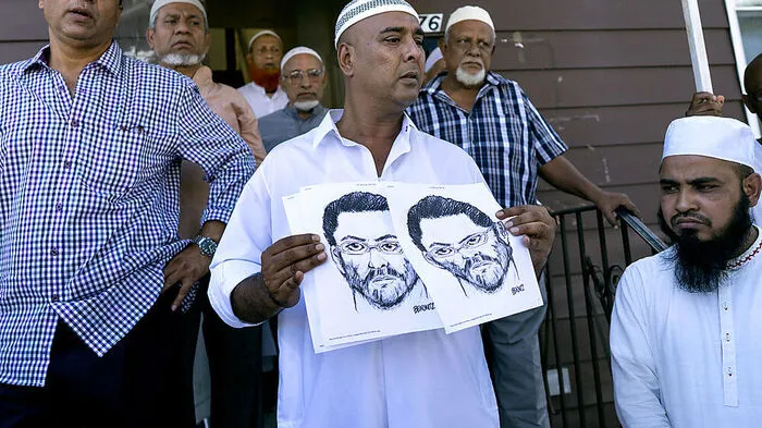 Muslime mit dem Fahndungsbild des mutmaßlichen Täters