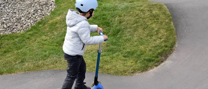 Ein junges Kind auf einem Scooter