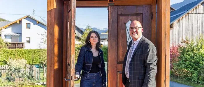 Eine Frau und ein Mann stehen in einer Türe, die ein Mahn- und Denkmal ist