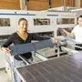 Zwei Damen stehen hinter mehreren Solarmodulen
