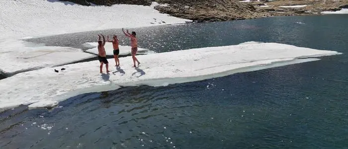 Drei Personen auf einer Eisscholle eines Gletschersees
