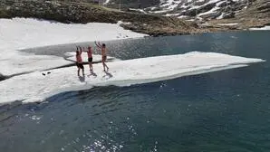 Drei Personen auf einer Eisscholle eines Gletschersees