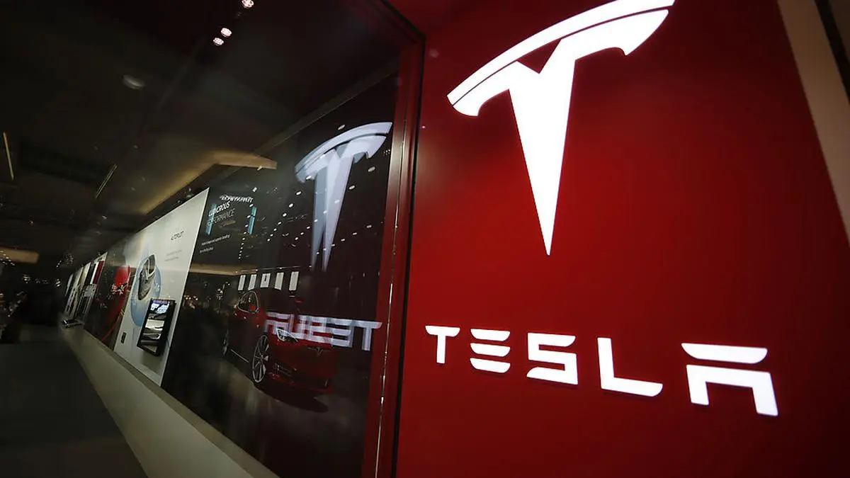 FILE- In this Feb. 9, 2019, file photo, a sign bearing the company logo is displayed outside a Tesla store in Cherry Creek Mall in Denver. The U.S. government’s highway safety agency says it’s gathering information on reports of malfunctions with a Tesla feature that lets drivers summon their cars in parking lots. The National Highway Traffic Safety Administration says it’s aware of reports about “Smart Summon” and is in contact with the company. Messages were left Thursday seeking comment from Tesla. (AP Photo/David Zalubowski, File)