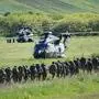 Spanish, German and Dutch soldiers next to military helicopters belonging to German, Spanish and Romanian armies at Bogata shooting range, Romania, on May 14, 2024, as part of military exercise Swift Response 24. More than 5,000 troops and 320 means of equipment from seven allied and partner states will participate over 5-24 May in SWIFT RESPONSE 24/ DEFENDER 24 Multinational Exercise conducted in Romania by the U.S. Army Europe and Africa (USAREUR-AF). Swift Response is part of Steadfast Defender 24, NATO’s largest military exercise since the Cold War. It is a dynamic US Army, Europe and Africa-led month long exercise across Europe from the Baltics to the Balkans. It focuses on the Allied airborne forces’ ability to quickly and effectively respond to crises. (Photo by Daniel MIHAILESCU / AFP)