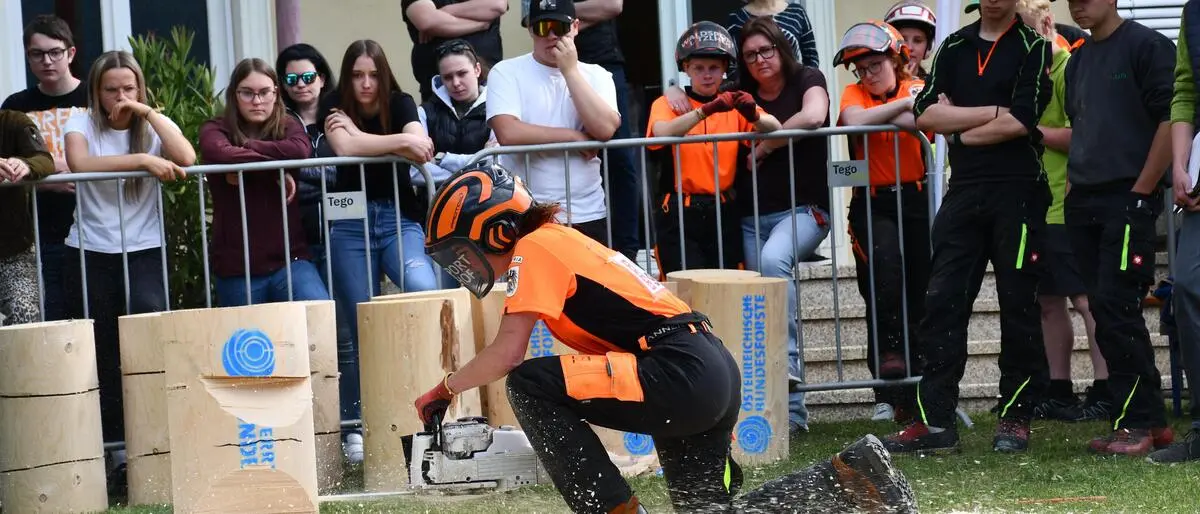 Ein Mädchen arbeitet mit der Motorsäge