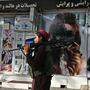 Ein Taliban-Kämpfer geht an einem Schönheitsssalon in Kabul vorbei - die Bilder der Gesichter der Frauen wurden besprayt