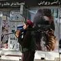 Ein Taliban-Kämpfer geht an einem Schönheitsssalon in Kabul vorbei - die Bilder der Gesichter der Frauen wurden besprayt