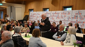 Im Kultursaal Hopfgarten hören viele Menschen den Worten von Pater Willibald Hopfgartner zu