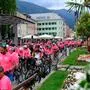 Radfans mit rosafarbenen Trikots starten in Lienz