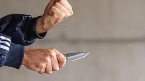Ein Mann zückt sein Messer