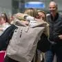 Menschen, die sich umarmen, auf einem Flughafen.