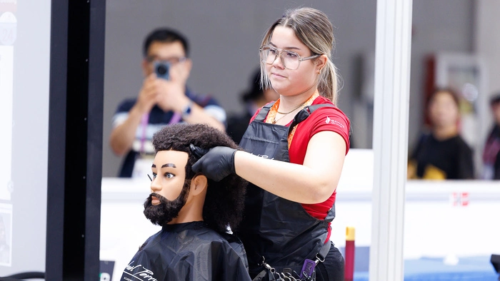Friseurin Angelina Rainer frisiert einen Übungskopf