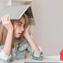 Eine Jugendliche mit sorgenvollem Gesicht hält einen Laptop über ihrem Kopf