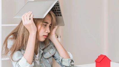 Eine Jugendliche mit sorgenvollem Gesicht hält einen Laptop über ihrem Kopf
