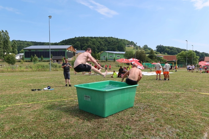 Die Teilnehmer mussten einen in die Luft katapultierten wassergefüllten Becher fangen, auf einer Decke stehend gezogen werden, kleine Bällchen weiterschlagen, auf große Holzsandalen in der Gruppe gehen, oder über einen Feuerwehrschlauch Luftballone aufblasen.