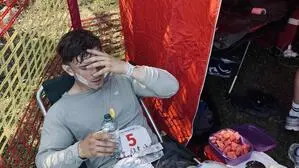 Ein Mann Anfang 20 sitzt völlig erschöpft von seiner sportlichen Tätigkeit in einem Stuhl.