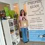Eine junge Frau steht in einem Raum und hinter ihr ist ein Banner mit der Aufschrift „Streuner Glück“.