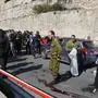 Israeli security forces and rescue teams inspect the scene of a shooting attack on February 22, 2024, near Maale Adumim settlement, east of Jerusalem. Three gunmen opened fire with automatic weapons on several vehicles near a Jewish settlement in the Israeli-occupied West Bank, killing at least one person and wounding many others in a "terror attack", police said. (Photo by AHMAD GHARABLI / AFP)