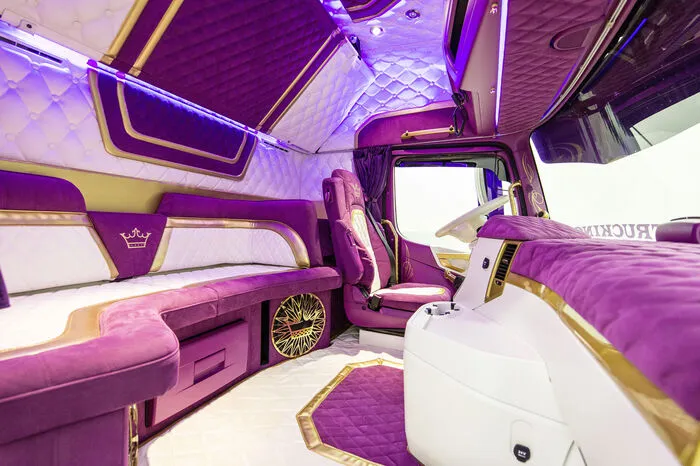 Die Fahrerkabine ist opulent mit weißem Glatt- und violettem Veloursleder in Rautensteppung ausgeschlagen und von goldenen Bordüren durchwirkt.