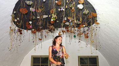 Katharina Steiner unter ihrer poetischen Installation einer umgekehrten Blumenwiese
