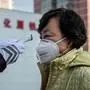 In this picture taken on January 31, 2020, a security guard checks the temperature of a woman wearing a protective mask as a preventative measure following a virus outbreak which began in the Chinese city of Wuhan, at the entrance of a park in Beijing. - China faced deepening isolation over its coronavirus epidemic on February 1 as the death toll soared to 259, with the United States leading a growing list of nations to impose extraordinary Chinese travel bans. (Photo by NICOLAS ASFOURI / AFP)