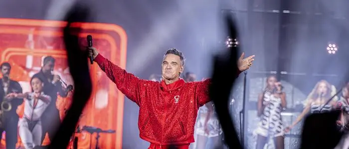 Robbie Williams in einem roten Anzug auf der Bühne | Robbie Williams schaute heuer im Wörthersee Stadion in Klagenfurt vorbei
