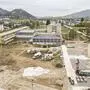 Eine Baustelle, im Hintergrund sind Berge zu sehen
