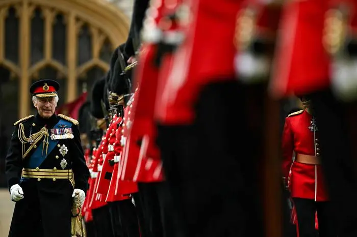 Britain's King Charles III (L) reviews the Irish Guards during a ceremony where he presents New Colours to No 9 and No 12 Company The Irish Guards at Windsor Castle, west of London, on June 10, 2024. The new Colours will be those trooped in the Trooping of the Colour at His Majesty’s official Birthday Parade in London on Saturday June 15, 2024. (Photo by Ben Stansall / POOL / AFP)