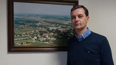 Der Neudauer Bürgermeister Wolfgang Dolesch vor einem alten Luftbild mit dem Werksgelände