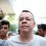 Pastor Andrew Craig Brunson (R), escorted by Turkish plain clothes police officers as he arrives at his house on July 25, 2018 in Izmir. - A Turkish court on July 25, 2018 ruled to place under house arrest an American pastor who has been imprisoned for almost two years on terror-related charges in a case that has raised tensions with the United States, state media said. The state-run Anadolu news agency said he was being put under house arrest, although it was not clear if he had already left prison. (Photo by STRINGER / AFP)