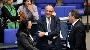 Friedrich Merz (2nd R), leader of Germany's conservative Christian Democratic Union (CDU) party, stands at the plenary hall during a session at the Bundestag (lower house of parliament) on March 18, 2025 in Berlin, Germany. German lawmakers will vote on a massive spending boost for defence and infrastructure proposed by chancellor-in-waiting Friedrich Merz amid concern over the United States' commitment to Europe's security. The hastily drawn plans represent a radical departure for a country traditionally reluctant to take on large amounts of debt or to spend heavily on the military, given the horrors of its Nazi past. (Photo by RALF HIRSCHBERGER / AFP)